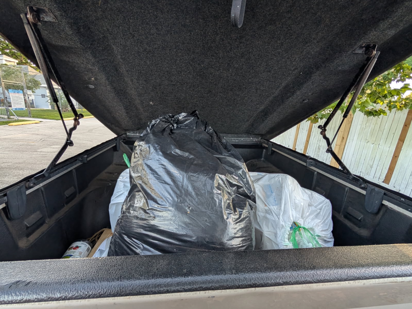 Community trash collection efforts - trash bins with bags near brick wall